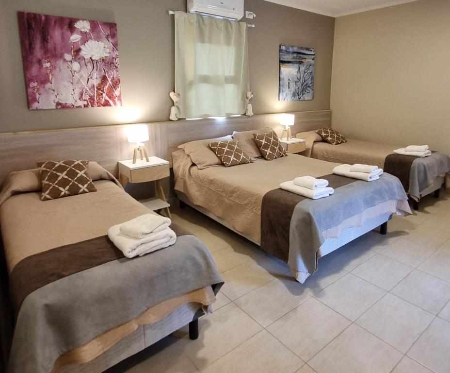 普洛缇尔Casas Noviembre的酒店客房,设有三张床和两张桌子