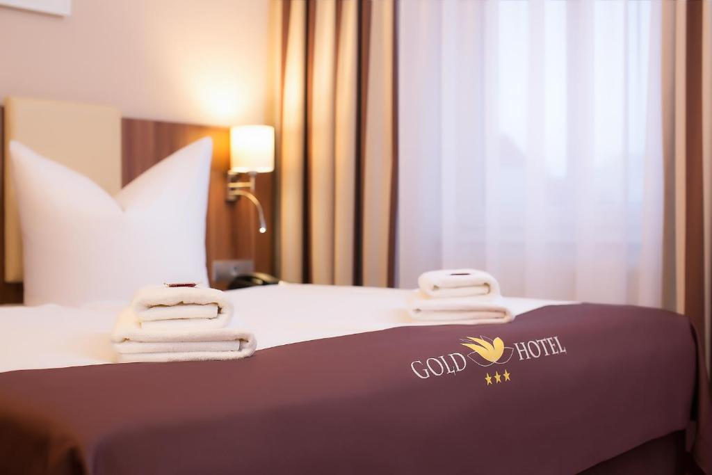 柏林金色酒店的酒店客房,配有带毛巾的床