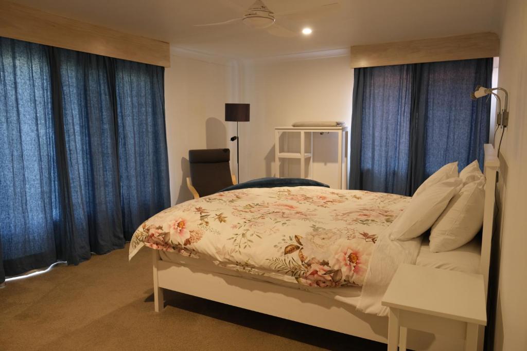 阿米代尔Twodogfolly at Creeklands的一间卧室配有一张带蓝色窗帘的大床