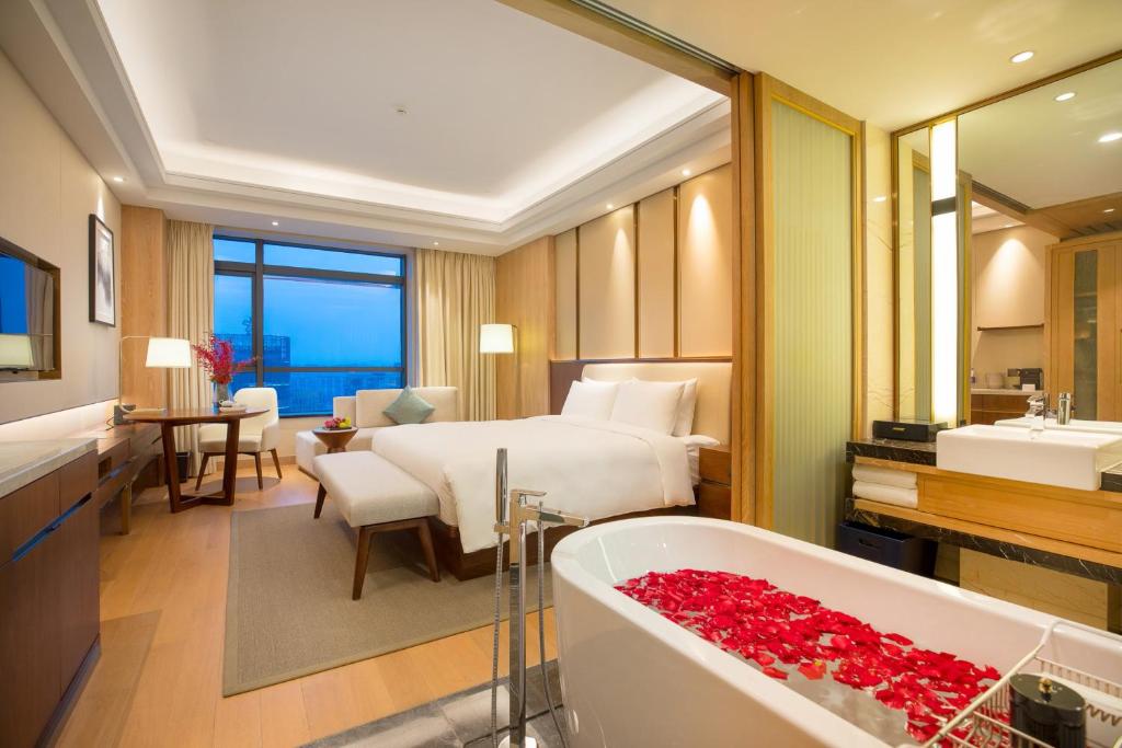 杭州杭州华盛达雷迪森广场酒店的酒店客房配有一张床和浴缸。
