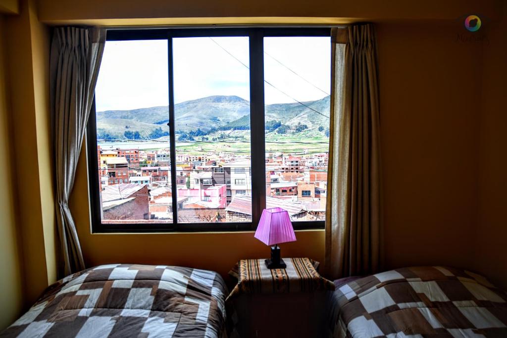 科帕卡巴纳solsticio hostel的一间卧室设有窗户、一张床和一盏灯。