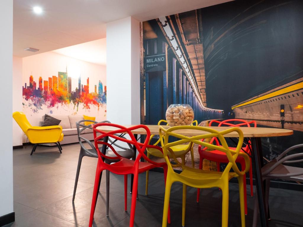 米兰Blocco Sauli的用餐室配有五颜六色的椅子和桌子