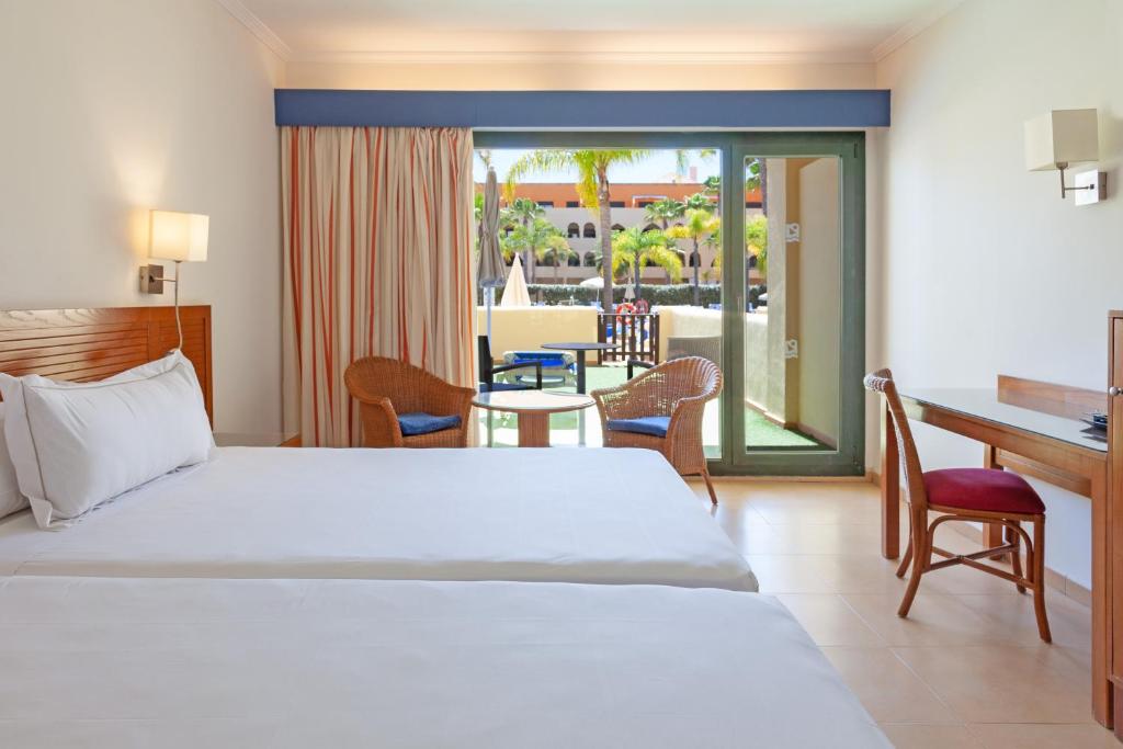 卡内拉岛Playamarina的一间卧室配有一张床、一张桌子和一张桌子