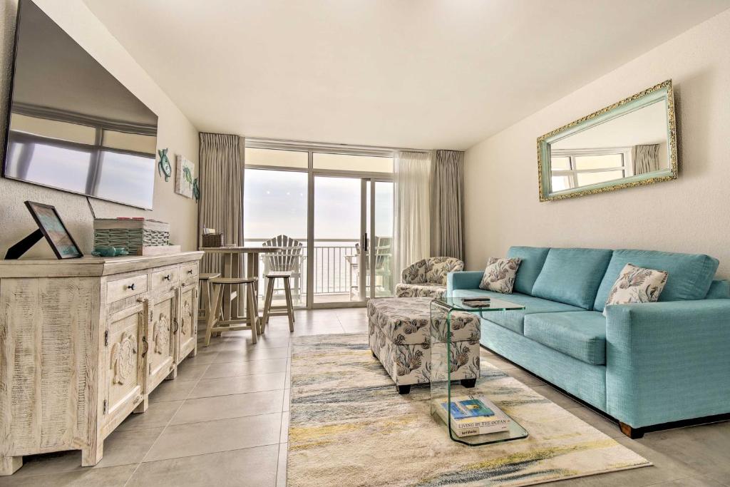 默特尔比奇Oceanfront Resort Condo in North Myrtle Beach的客厅配有蓝色的沙发和桌子