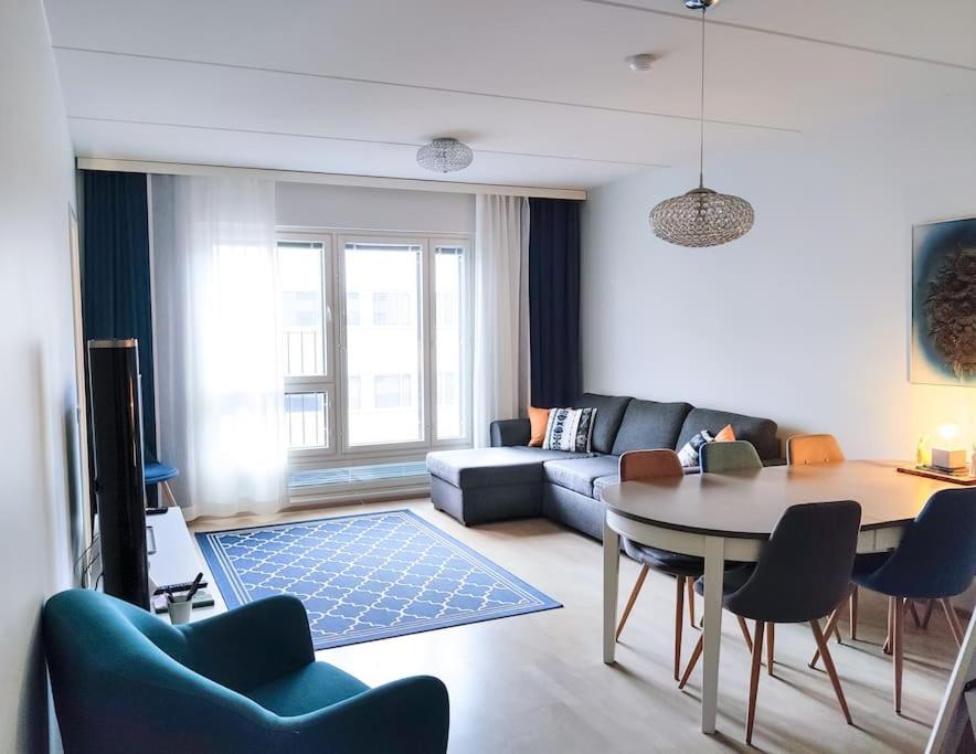 于韦斯屈莱Alvar, Tilava uusi kaksio ydinkeskustassa 53 m2的客厅配有桌子和沙发