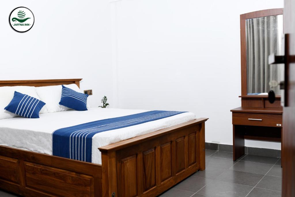 贾夫纳Jaffna Inn的一间卧室配有蓝色和白色床单
