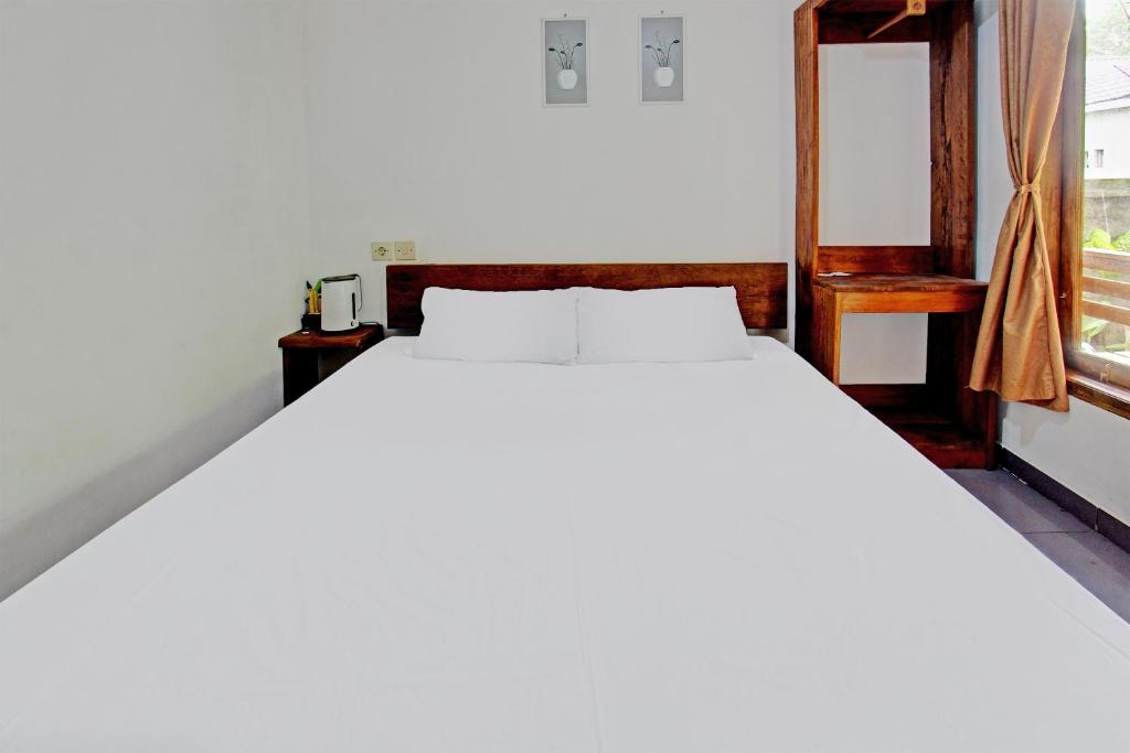 普拉亚Tastura Homestay的窗户客房内的一张白色床