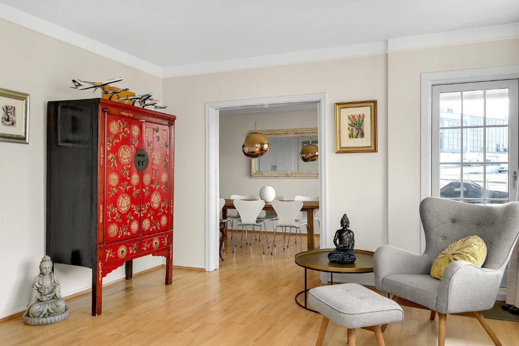 雷克雅未克Cozy and Quiet 2BR Apartment的客厅配有红色橱柜和桌椅