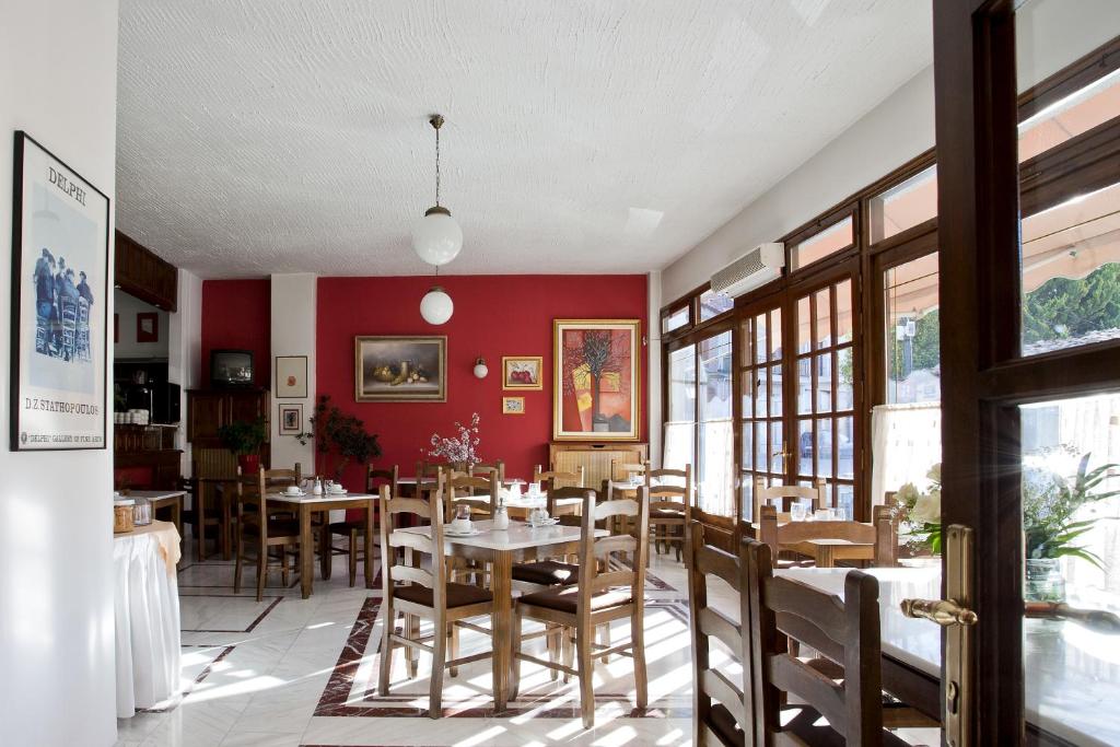 特尔斐克鲁罗斯酒店的一间拥有红色墙壁和桌椅的用餐室