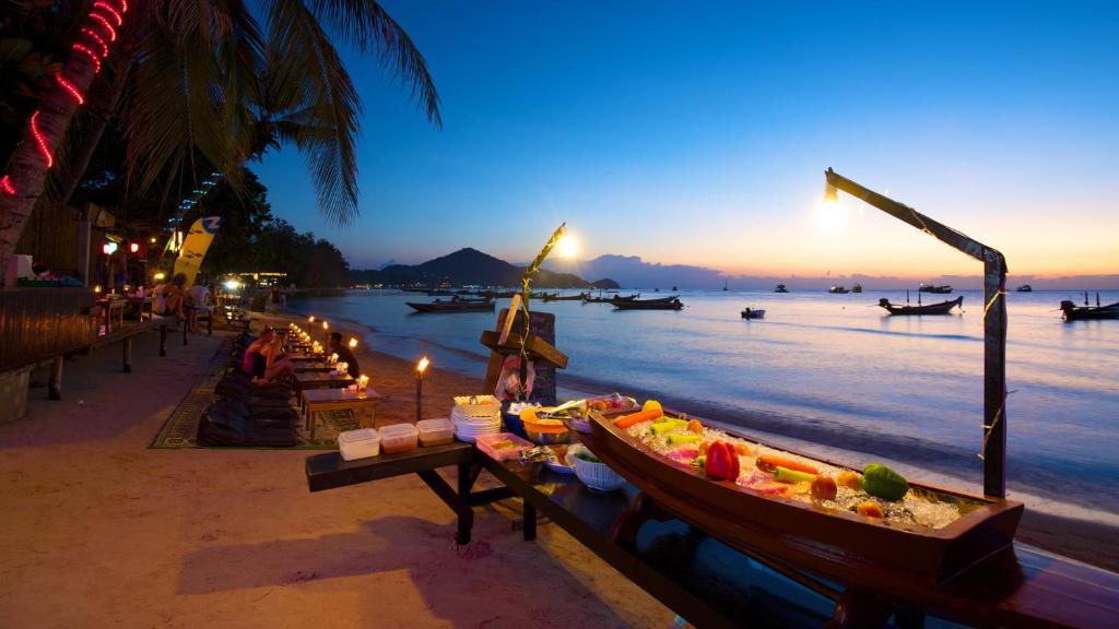 涛岛海滩之风度假村的黄昏时在海滩上装满食物的船只