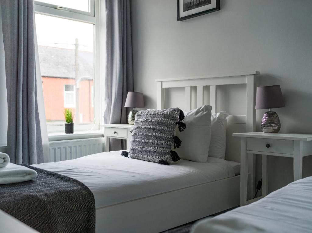 ChoppingtonEast House - Inviting 3 Bed Stakeford的一间卧室配有一张带枕头和窗户的床
