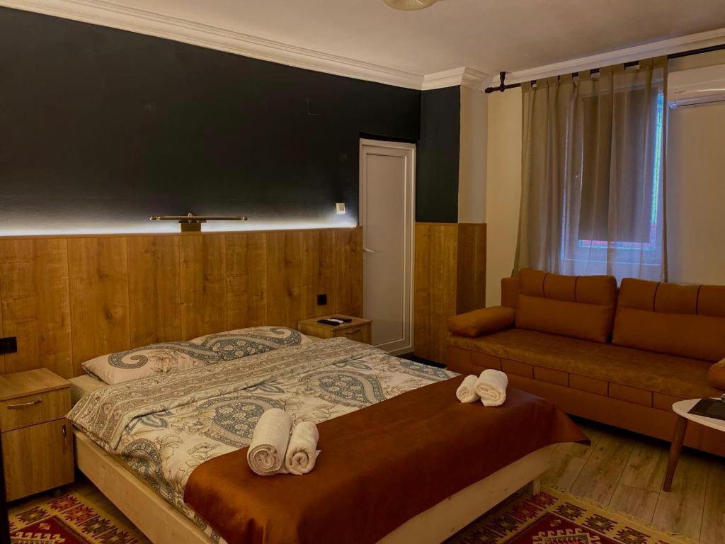 普里什蒂纳Hotel Lido的一间卧室配有一张大床和一张沙发