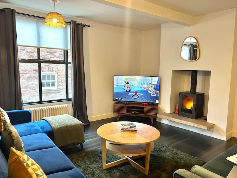 曼彻斯特Central, Unique 4-Storey House in Northern Quarter, Manchester的客厅配有蓝色的沙发和电视