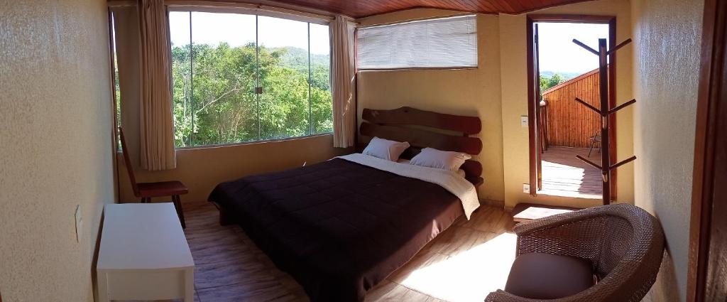 戈亚斯州上帕莱索Santuário na Chapad a dos Veadeiros的一间卧室设有一张床和一个大窗户