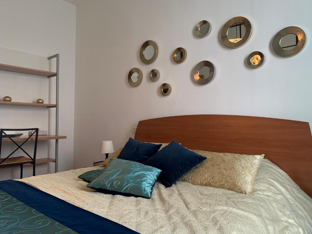 威尼斯Appartement GIUDECCA的一间卧室配有一张带蓝色枕头的床,墙上挂有钟。