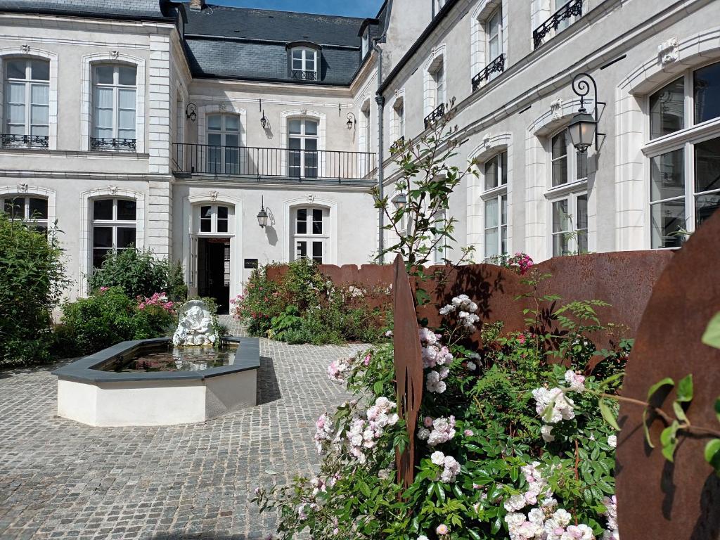 蒙特勒伊Hôtel Loysel le Gaucher的建筑前带喷泉的庭院