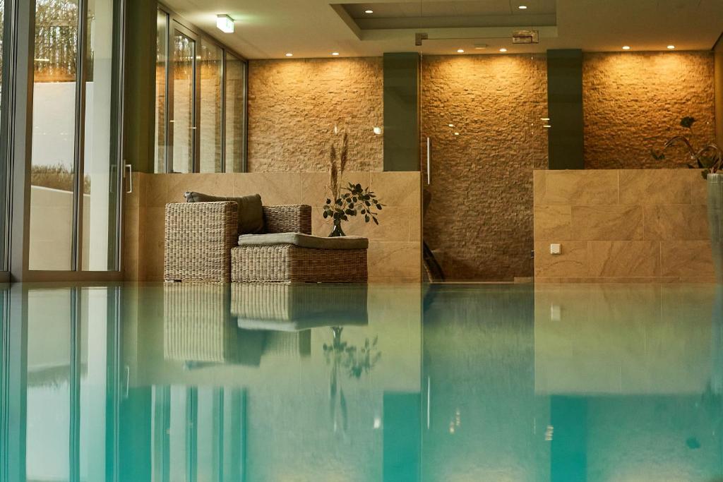 蒂门多弗施特兰德罗曼蒂克负和淄博酒店的大堂设有沙发,位于游泳池的顶部