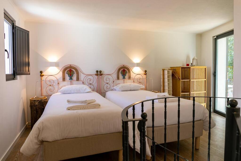辛特拉Casinha - Lusitália Eden的一间卧室设有两张床和窗户。
