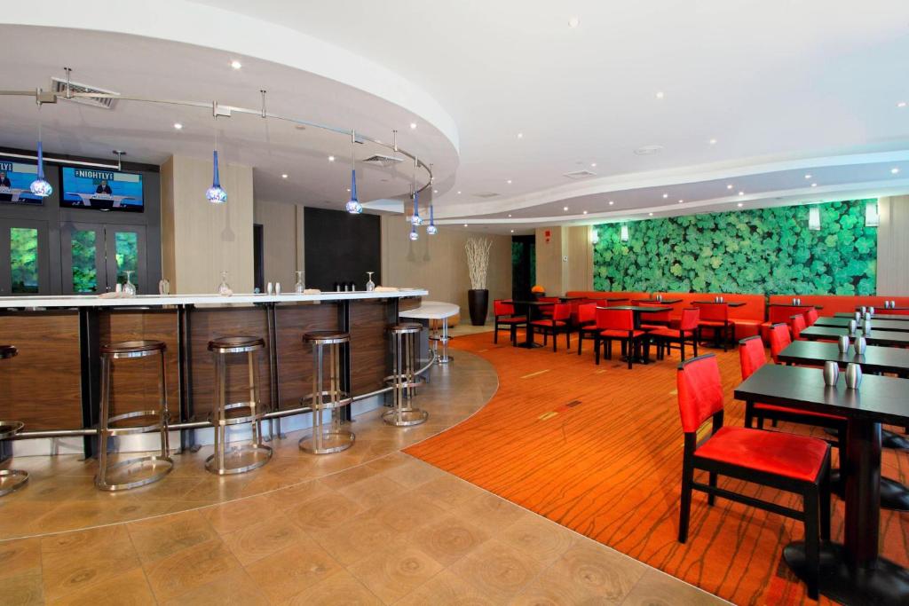 林德赫斯特林德赫斯特梅多兰兹万怡酒店的餐厅设有酒吧和桌椅