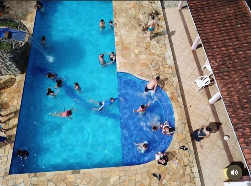 若阿诺波利斯Pousada camping Recanto Joanópolis的一群人在游泳池游泳