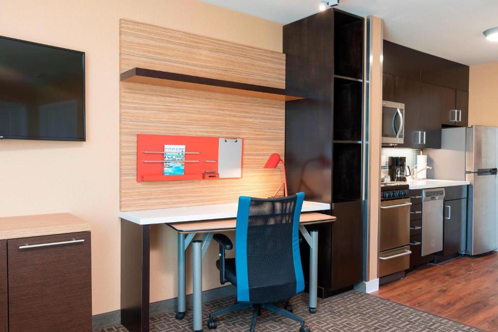 曼斯费尔德TownePlace Suites by Marriott Ontario-Mansfield的小厨房配有书桌和蓝椅