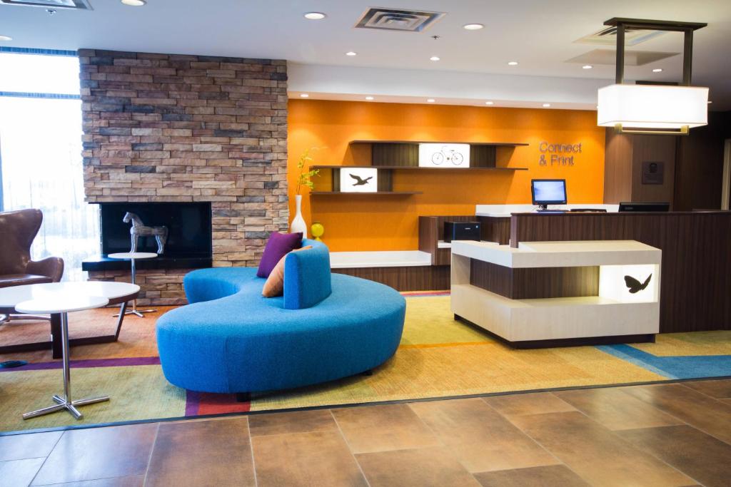 布赖顿Fairfield Inn & Suites by Marriott Denver Northeast/Brighton的客厅设有蓝椅和壁炉