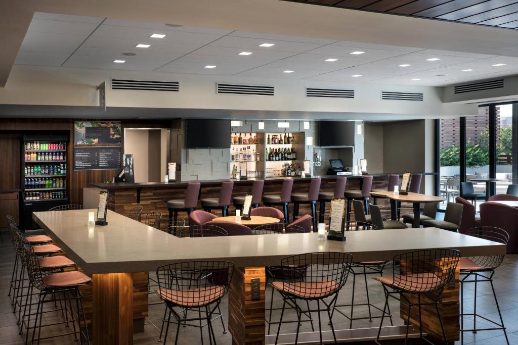 奥罗拉盖特威公园丹佛机场万怡酒店的餐厅设有酒吧,配有桌椅