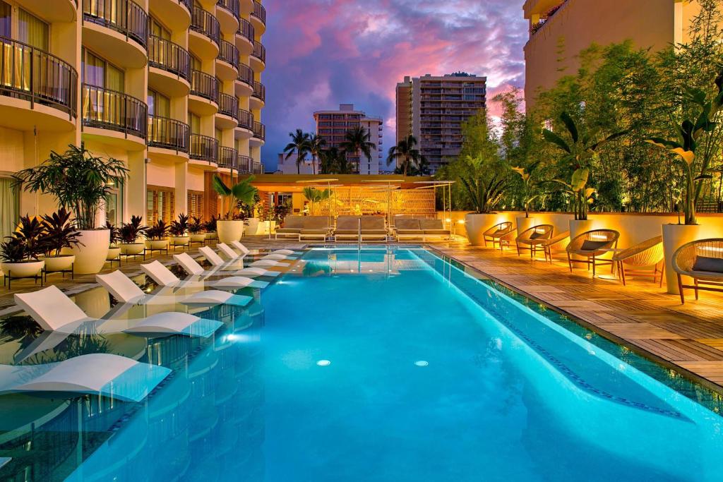 檀香山雷洛傲途格精选酒店的一个带躺椅的游泳池和一间酒店