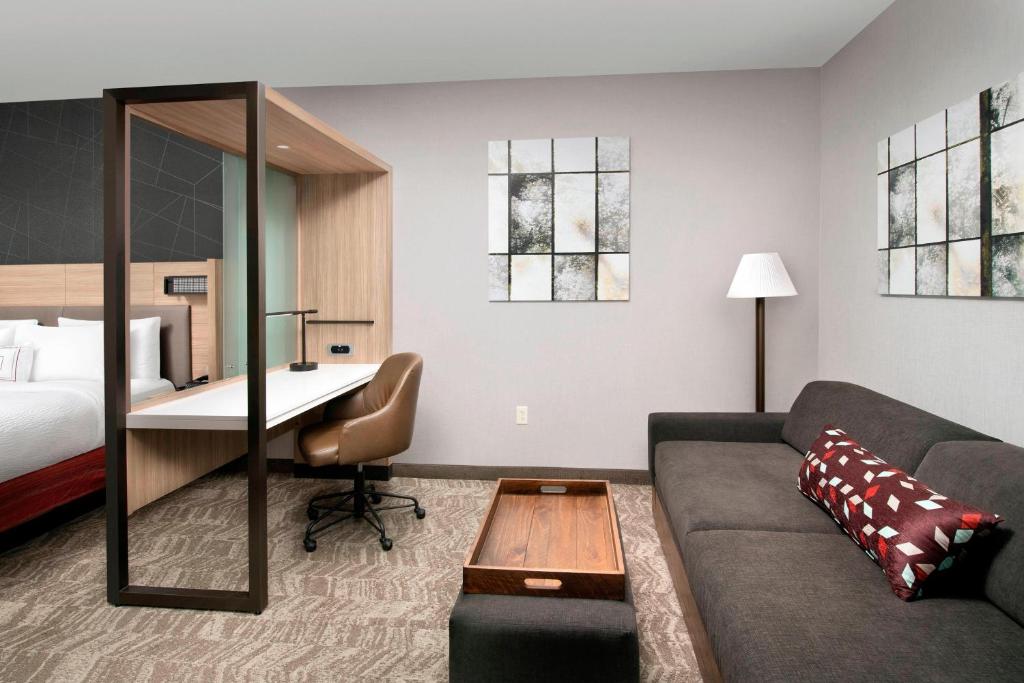 阿拉米达SpringHill Suites by Marriott Albuquerque North/Journal Center的一间客厅,客厅配有沙发和一张书桌,位于酒店的房间