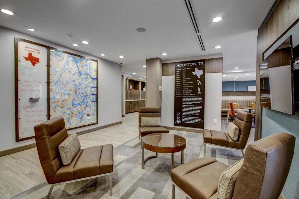 休斯顿TownePlace Suites by Marriott Houston Hobby Airport的医院里的一个等候区,有椅子和桌子