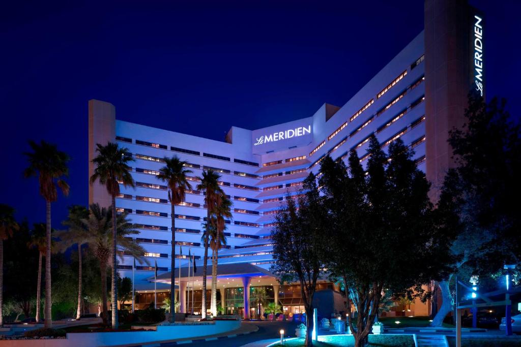 阿可贺巴艾美度假酒店的一家在晚上拥有棕榈树的酒店