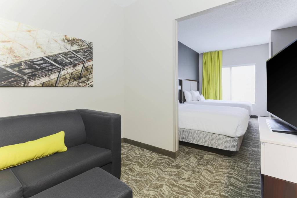 奥斯汀SpringHill Suites by Marriott Austin Parmer/Tech Ridge的酒店客房设有一张沙发和一张床