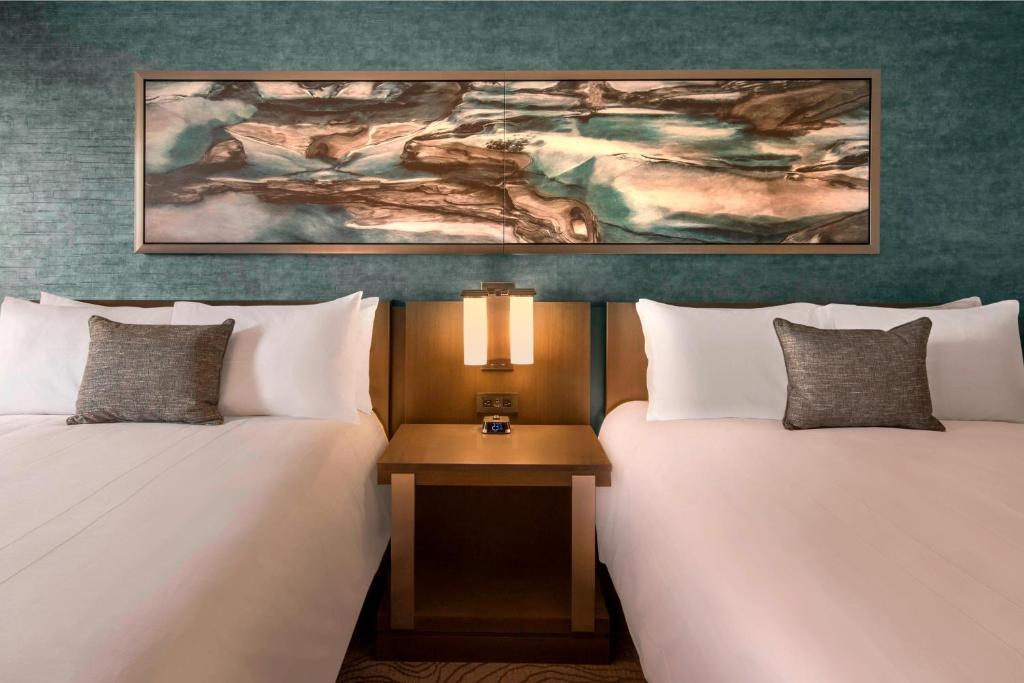 格林伍德村丹佛技术中心万豪酒店的两张位于酒店客房的床,墙上挂着一幅画
