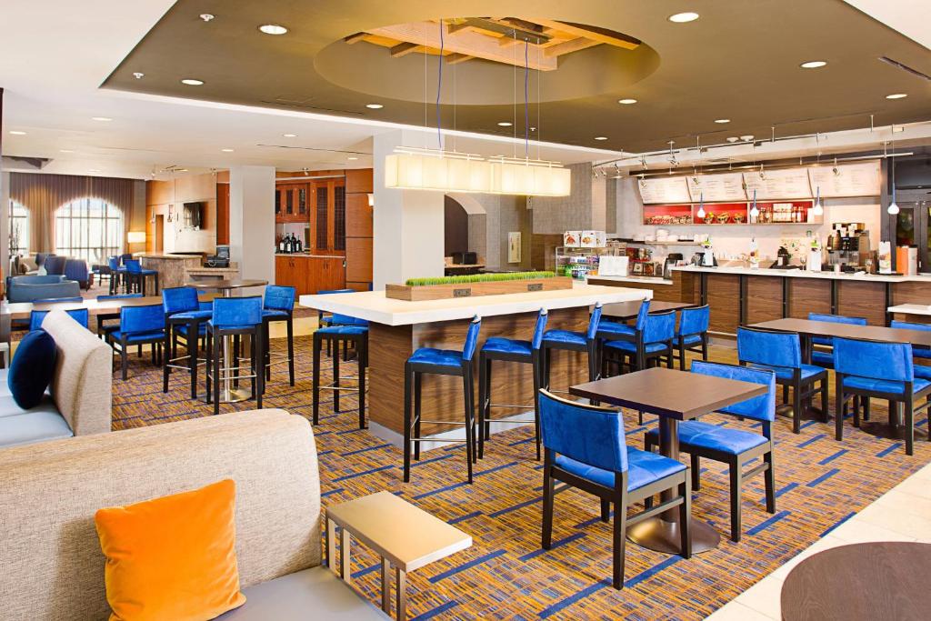 佩索罗伯斯帕索罗布莱斯万怡酒店的一间设有蓝色桌椅的餐厅和一间酒吧