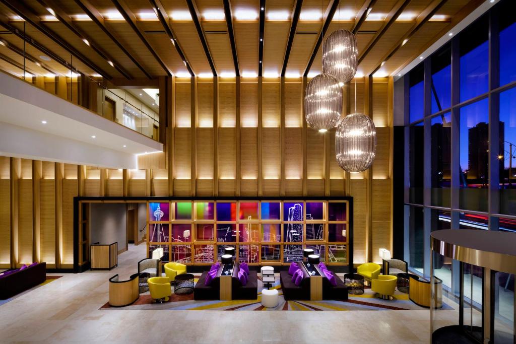 多伦多马里奥特多伦多德尔塔酒店的大堂设有黄色和紫色的椅子和桌子