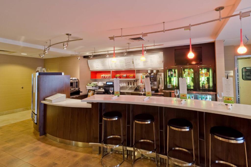 雷顿盐湖城雷顿万怡酒店的厨房设有带凳子和冰箱的酒吧。
