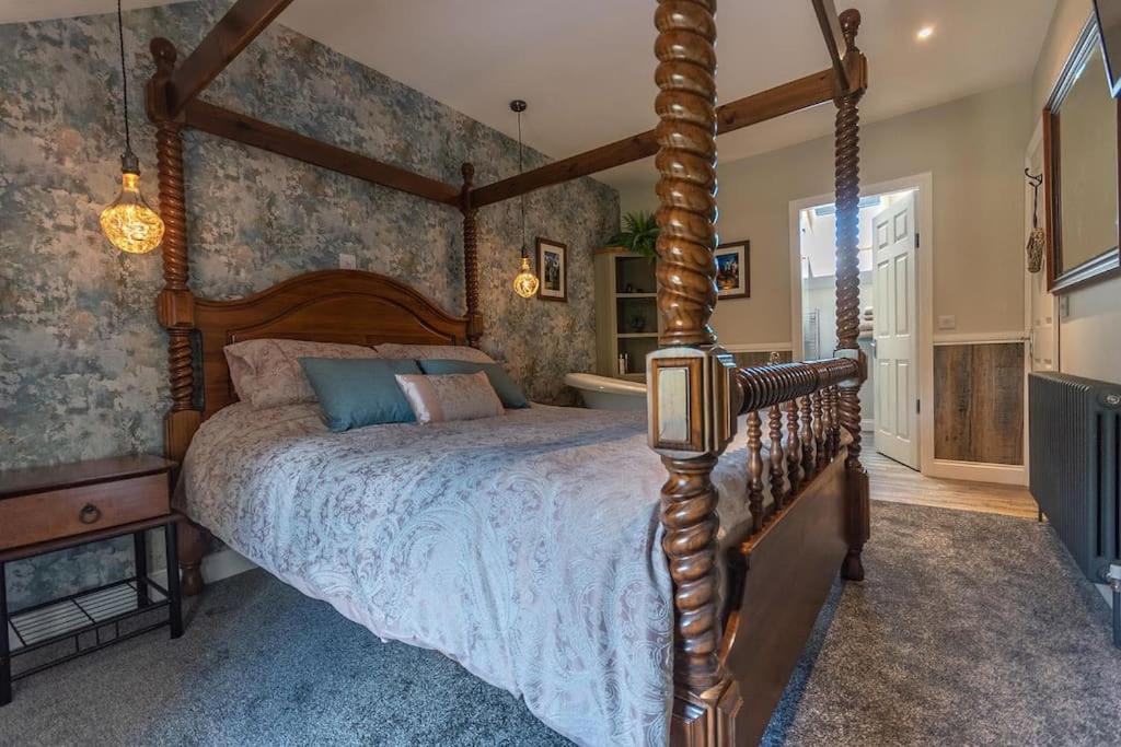 CranwellLuxury retreat in Lincolnshire with hot tub的一间卧室配有一张木天蓬床。