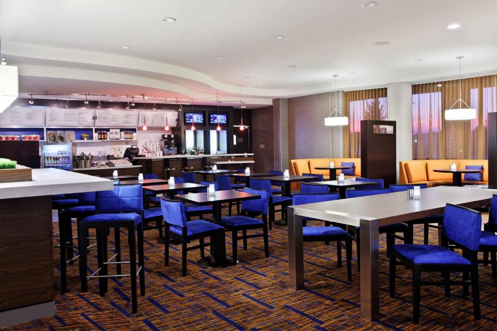 阿尔科Courtyard by Marriott Knoxville Airport Alcoa的一间配备有桌子和蓝色椅子的用餐室