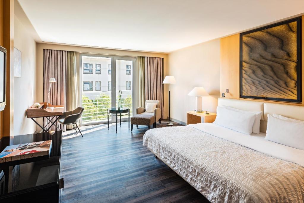 慕尼黑慕尼黑艾美酒店的配有一张床和一张书桌的酒店客房
