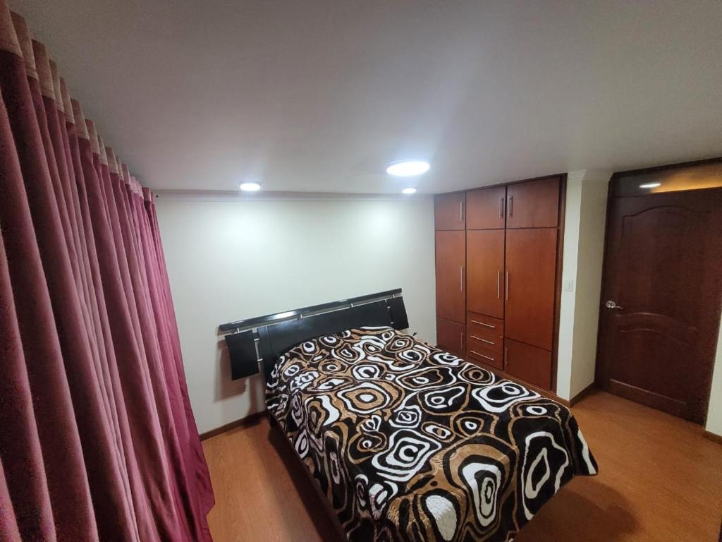 伊皮亚莱斯Casa Grande con parqueadero的一间卧室配有床、橱柜和窗帘