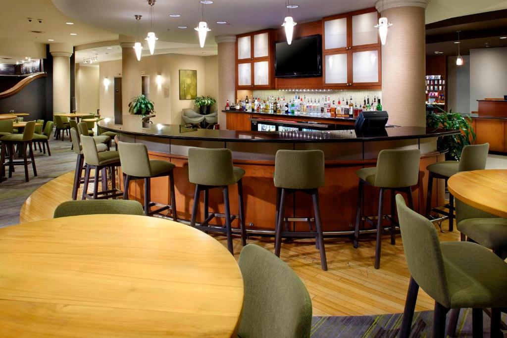 雷丁利丁怀奥米辛万怡酒店的餐厅内的酒吧配有桌椅