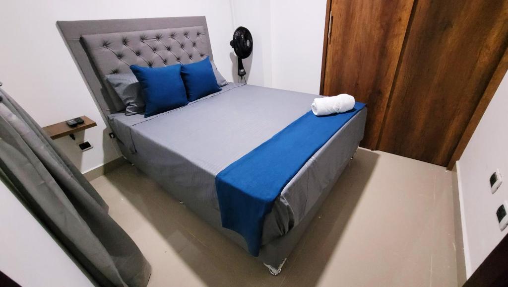 贝约ANDALIVING NIQUIA APARTAMENTO的享有带蓝色枕头的床铺的上方景色