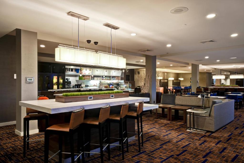 海恩尼斯海恩尼斯科德角万怡酒店的餐厅设有酒吧,配有桌椅