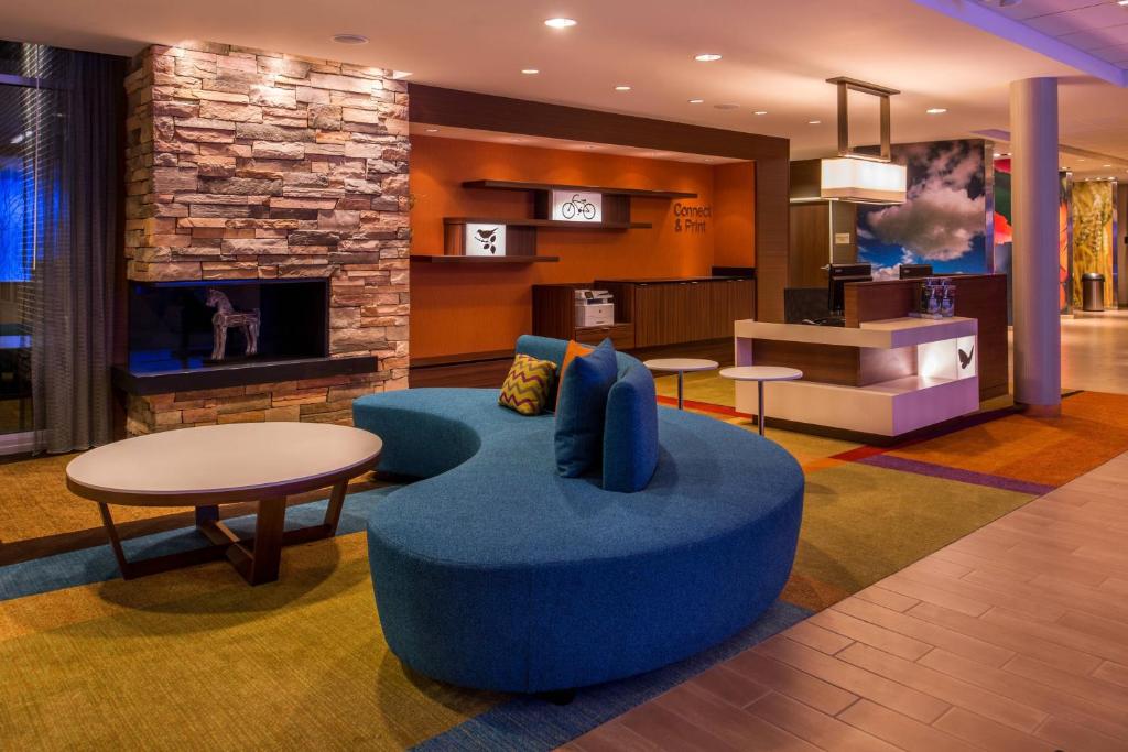 马里兰高地Fairfield Inn & Suites by Marriott St. Louis Westport的客厅设有蓝色的沙发和壁炉