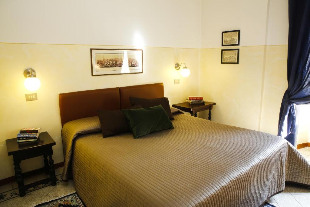 博洛尼亚艾尔伯格加里胜大酒店的一间卧室配有一张带两张桌子和两盏灯的床。