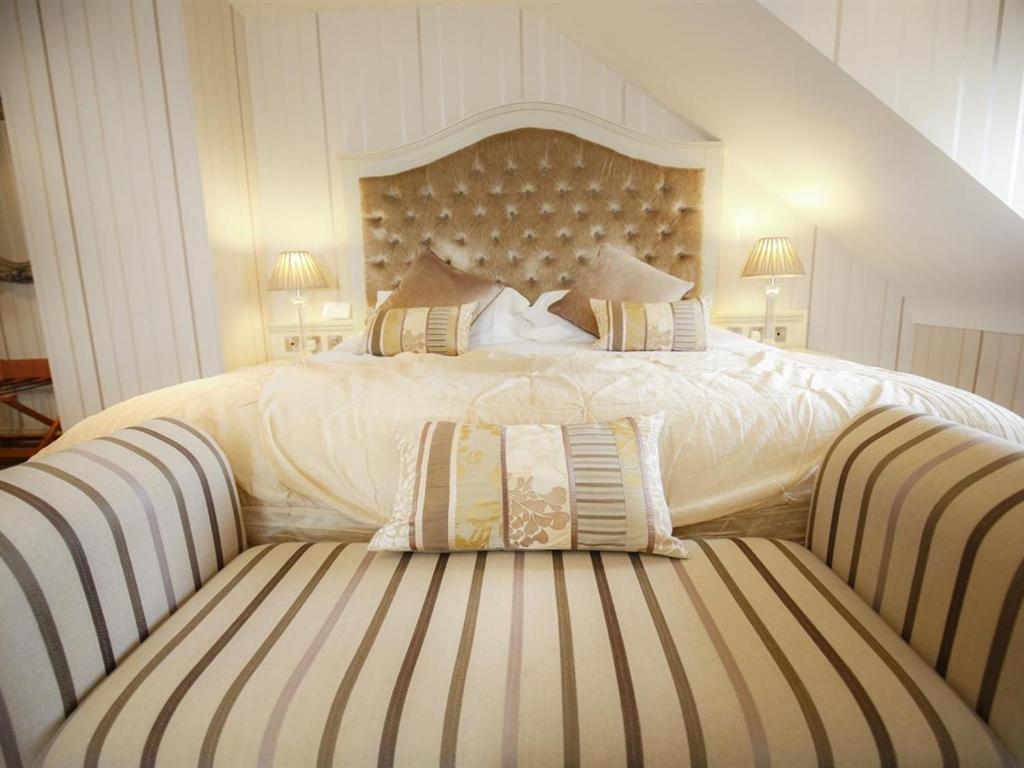 Belcoo海关大楼乡间旅馆的一间卧室配有一张大床和条纹沙发