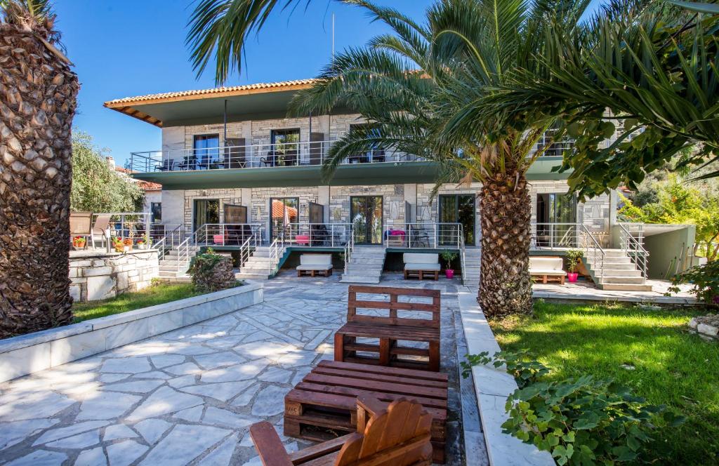 斯卡拉索提罗斯Marti Resort的院子内有长椅和棕榈树的房子