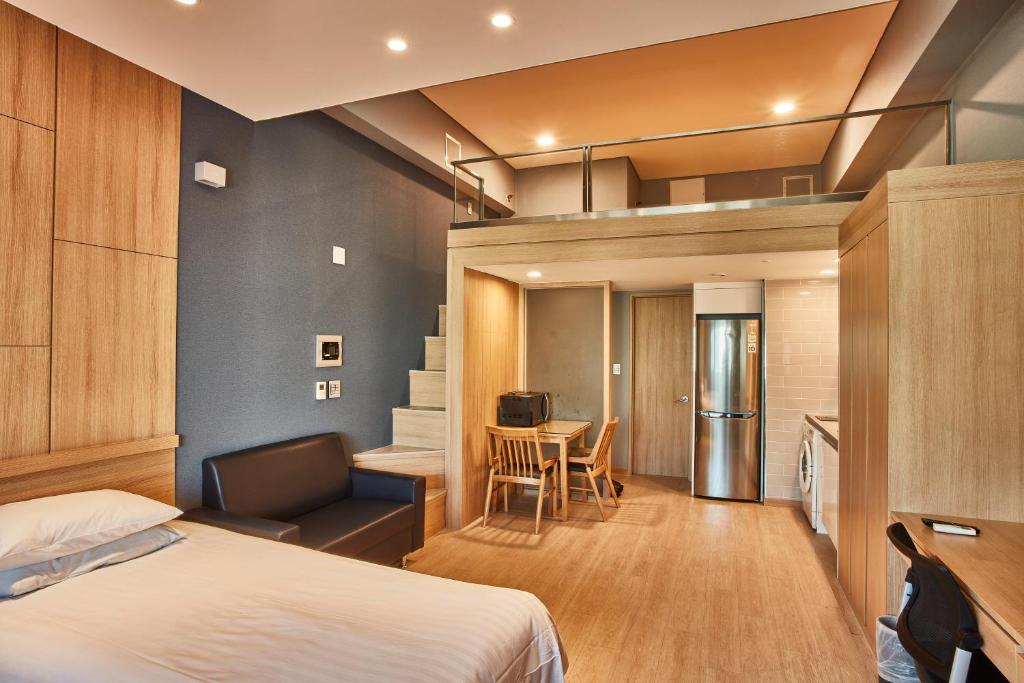 首尔Provista Hotel的一间带一张床和一张书桌的卧室和一间厨房