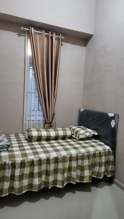 HalanganHomeStay Pandan Baru的一张带 ⁇ 子毯子和窗户的床