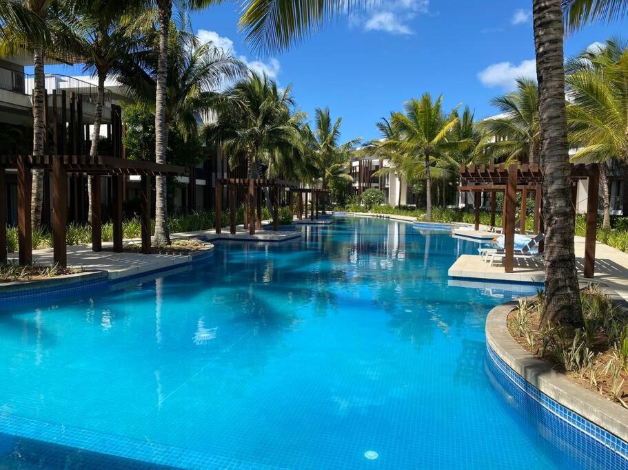 蒙舒瓦西LUX APPARTMENT GOLF DE MONT CHOISY的度假村内一座种有棕榈树的大型游泳池